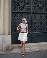 a lady wears a striped tank top with white shorts